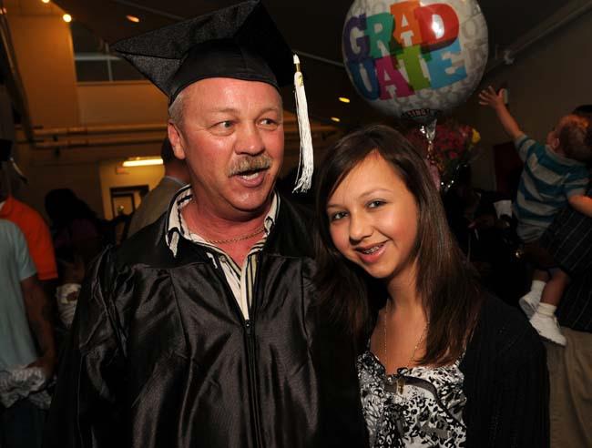Father graduates from the Hubbs Center with his GED! Standing next to him is his daughter.